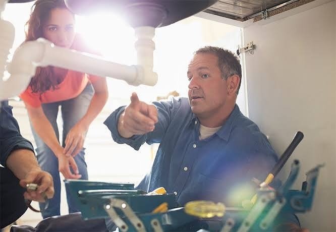 Licensed plumber explaining repair options to Broomfield homeowner